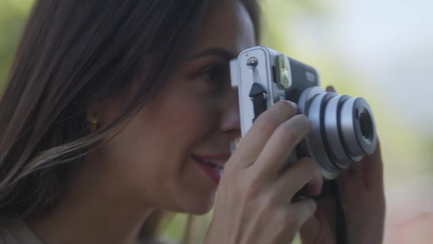 Female photographer give instructions while taking pictures before laughing
