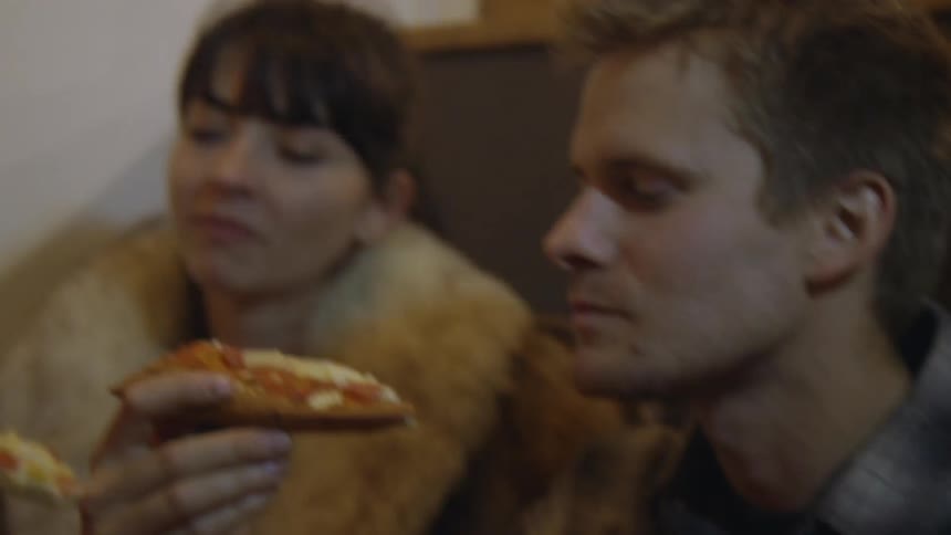 People are sitting together eating pizza