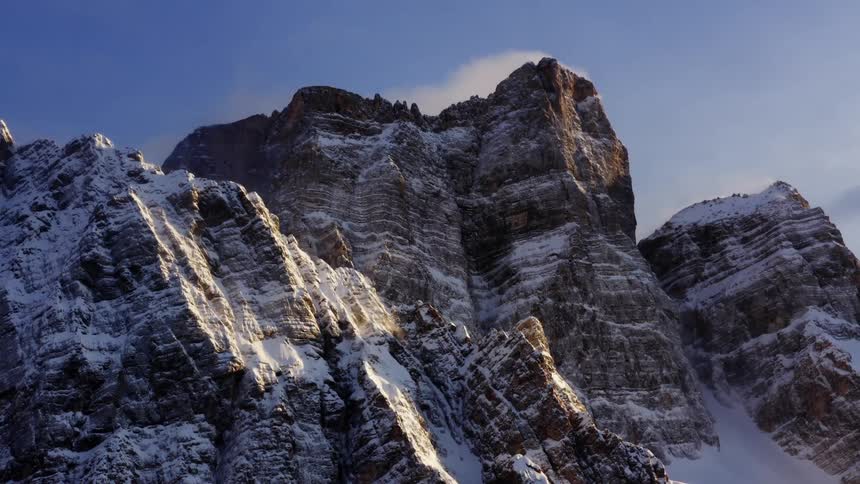 Snow covers the mountain range under a sunny blue sky