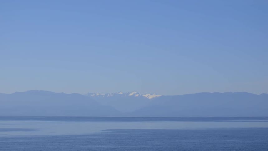 A mountain range in front of a lake