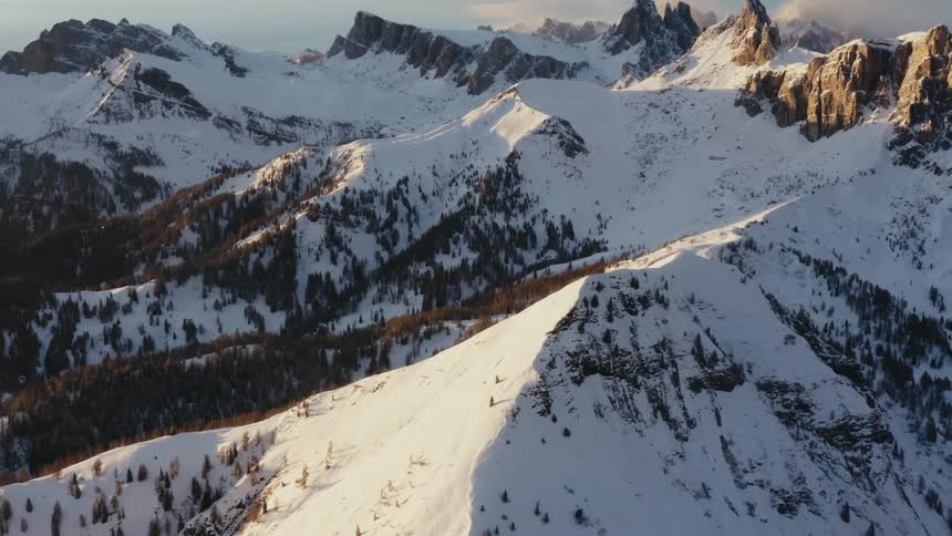 Snow covered mountain ridges and slopes with evergreen trees