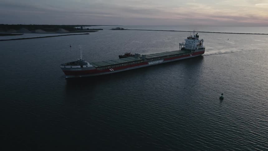 Long narrow ship travels in the river