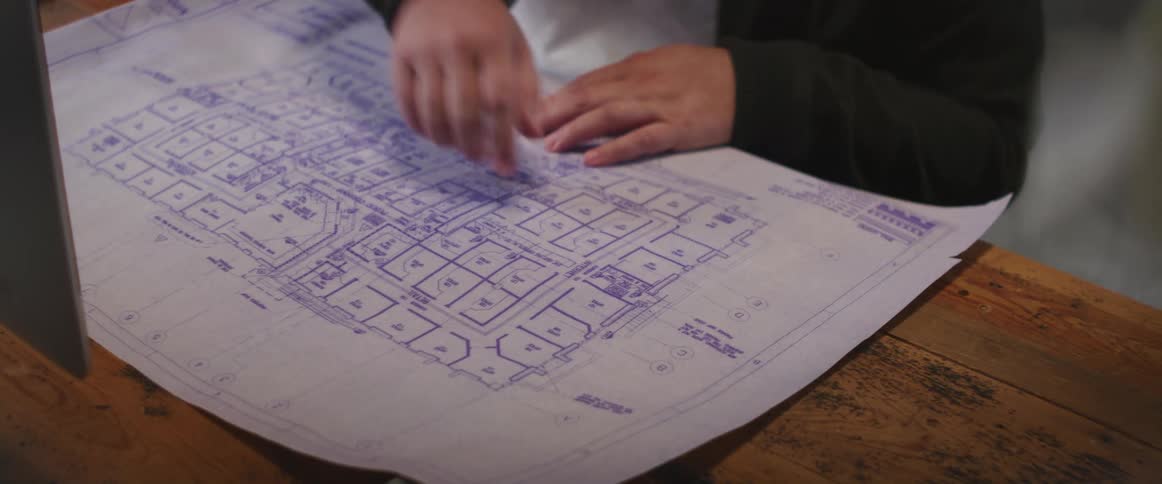 A person is looking at a diagram and sitting at a desk