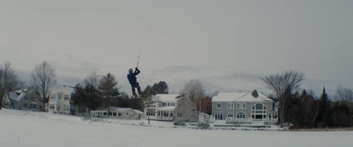 A paragliding skier is lifted off the ground and into the air