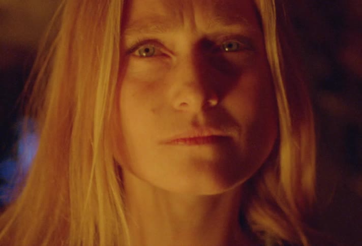 A woman looks around a dark cave