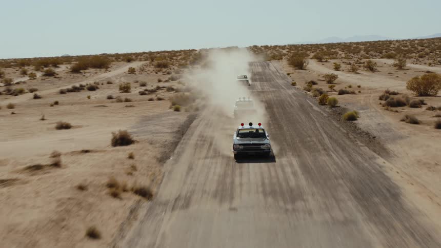 Aerial view of police car driving on dirt road