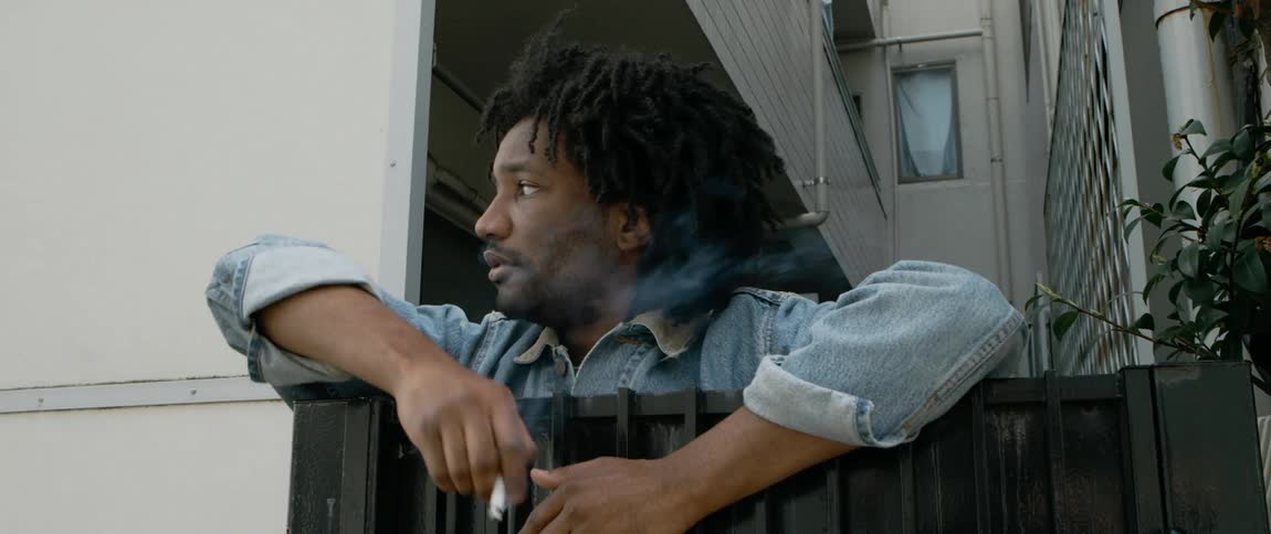 A man is smoking against the gate