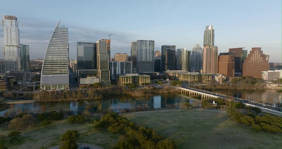 Aerial view of city skyscrapers next to bridge over river