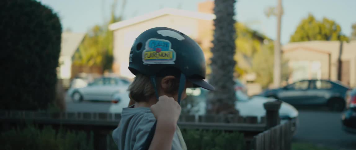A child runs out of the house and gets on his bike