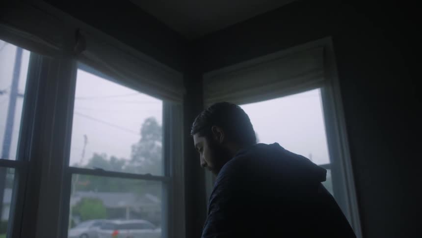 Man stands near windows in a house