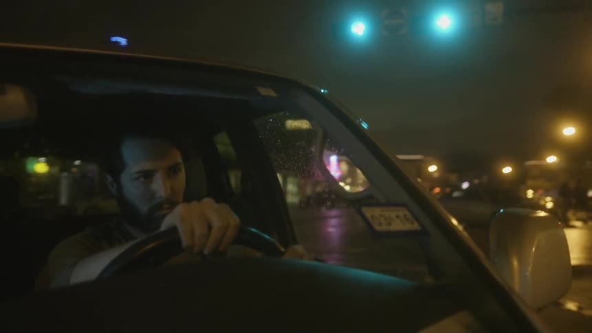 Close up of a man driving a car and making a turn