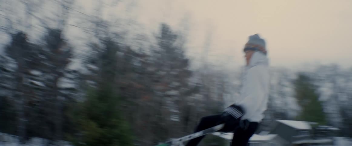 A boy is skating across the ice with a hockey stick