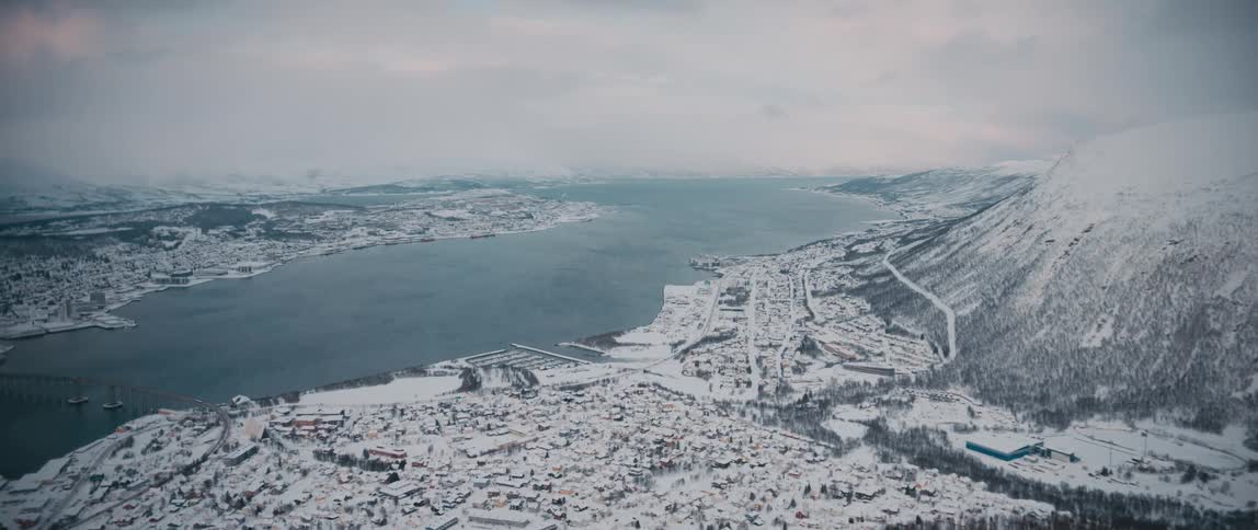 A snow covered village along the water in norway