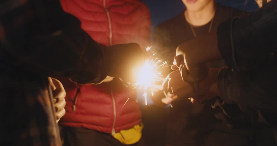 A group of friends are outdoors with fireworks