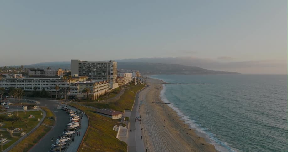 Waves crash onto the beach alongside apartment buildings
