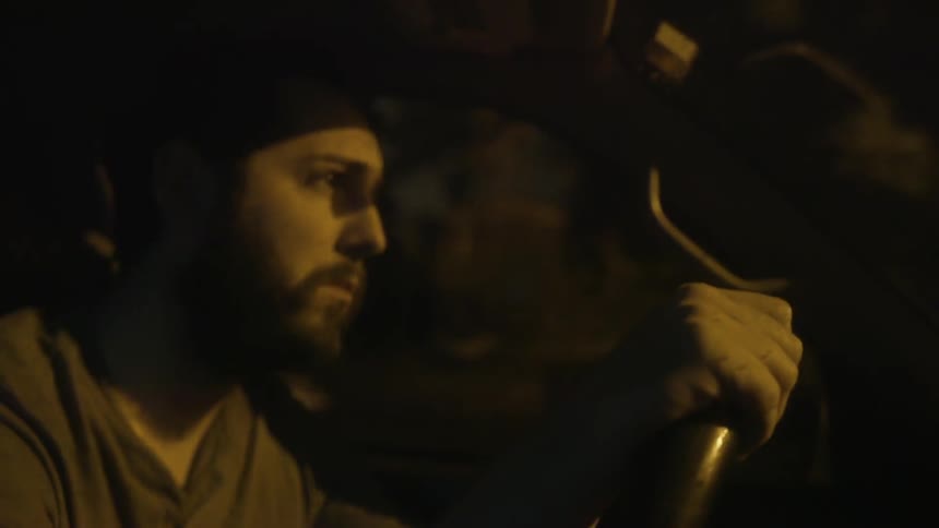 A man is driving a car at night