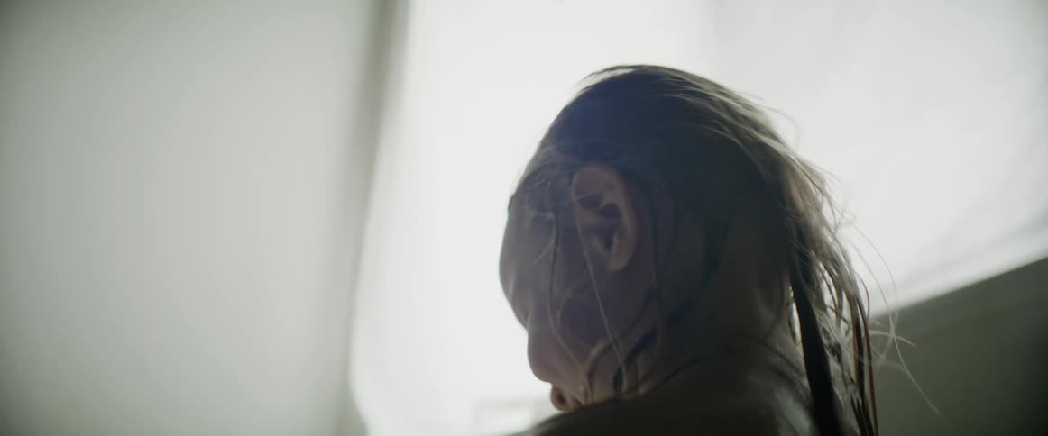 A little girl stands out of the bathtub and smiles