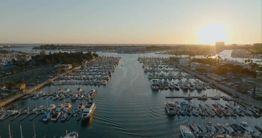 An aerial view of boats in the water and cars driving on streets around the water