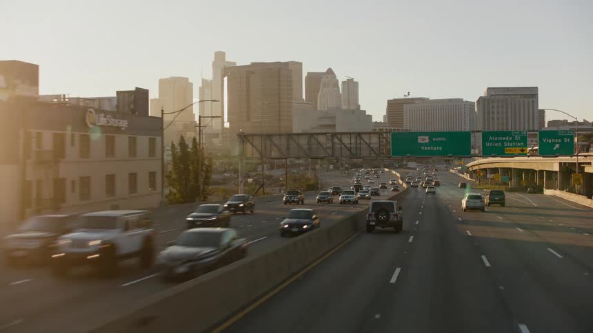Vehicles speed on a highway headed toward and out of downtown