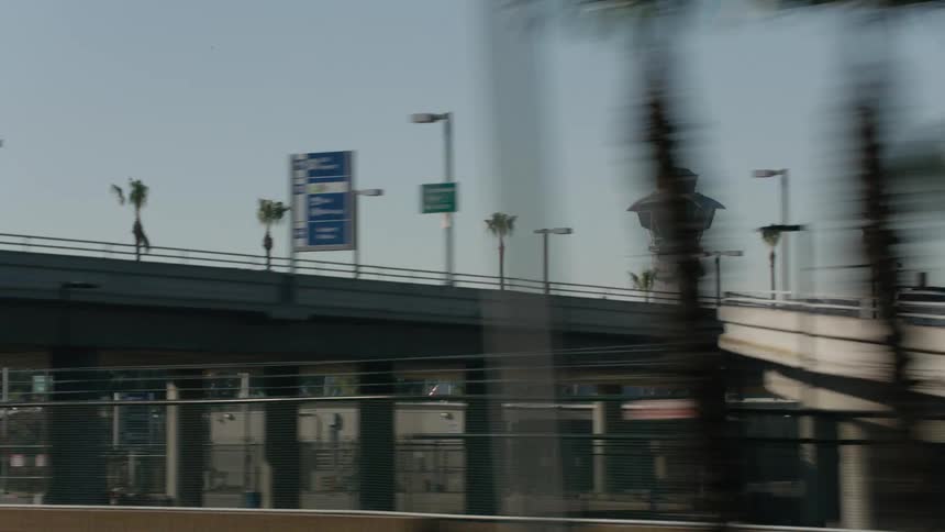 Cars are driving on a highway near a city during the daytime