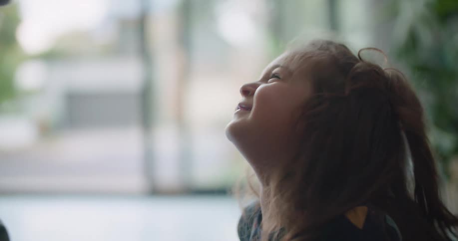 A dad and his daughter rub noses and laugh
