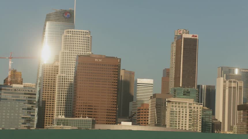 Rotating city skyline with office buildings and skyscrapers at sunset