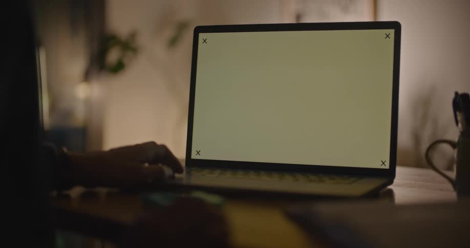 A person sitting in front of a laptop computer is tapping their fingers as they look at a blank screen