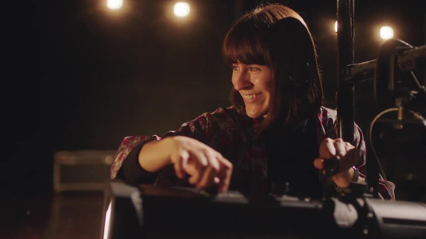 A woman is using a camera on stage