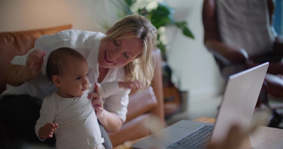 A mother and daughter wave at the laptop