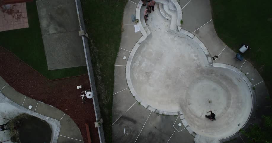People are skateboarding in a large empty pool