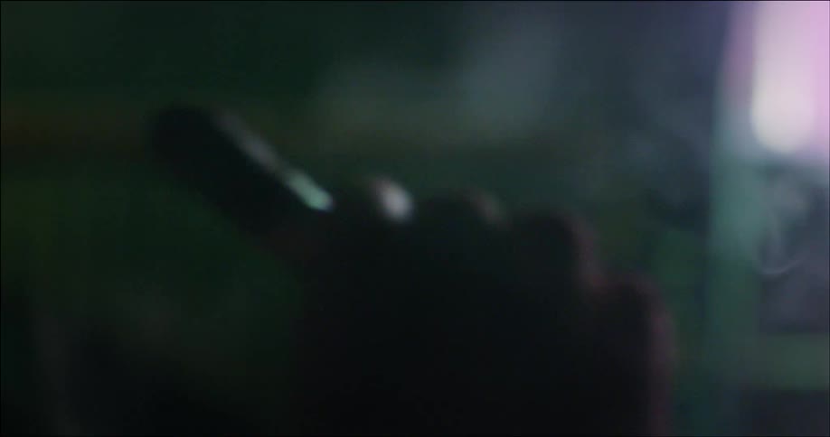A man is smoking in a dark area