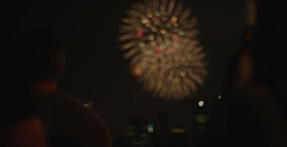 Fireworks are exploding over a city at night