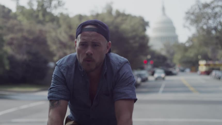 A man is riding his bike down a city street