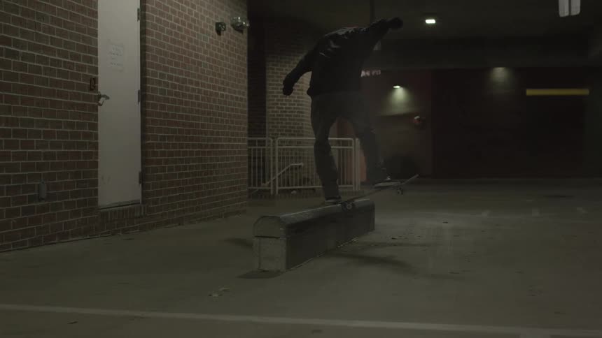 Man does a trick on a skateboard at night