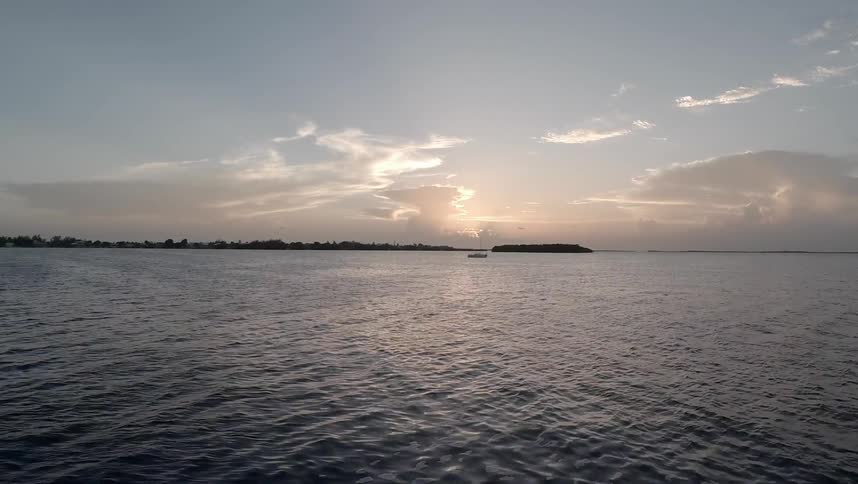 A person paddle boarding near sunset