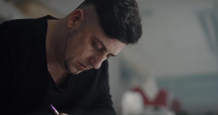 A man is sitting down writing