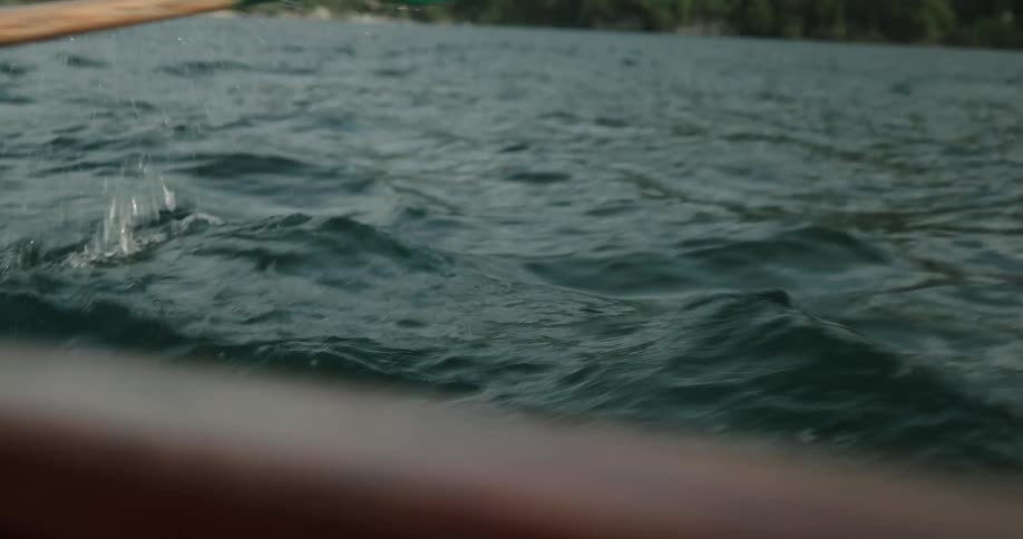 A person is rowing a boat on a lake during the day