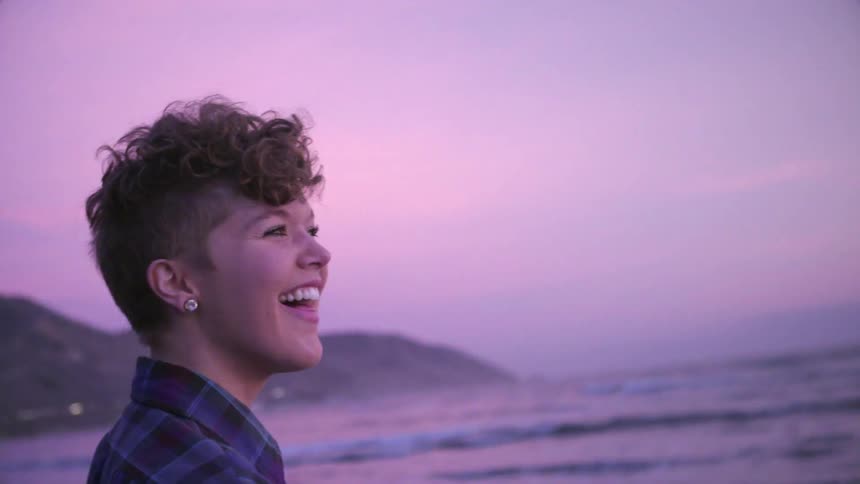 A woman is laughing on the beach