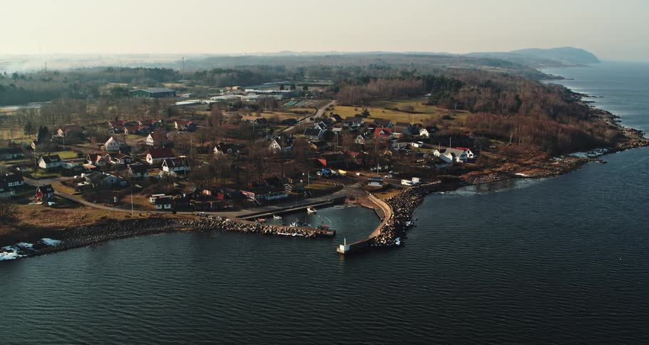 Aerial view of the bay in front of a a calm small coastal town close to the ocean at morning