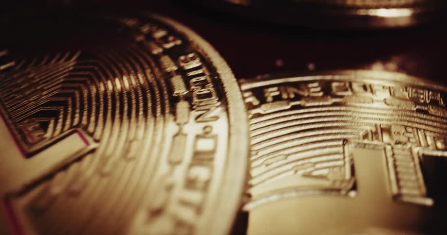 Close up of the shiny engraved surface of golden bitcoin physical coins