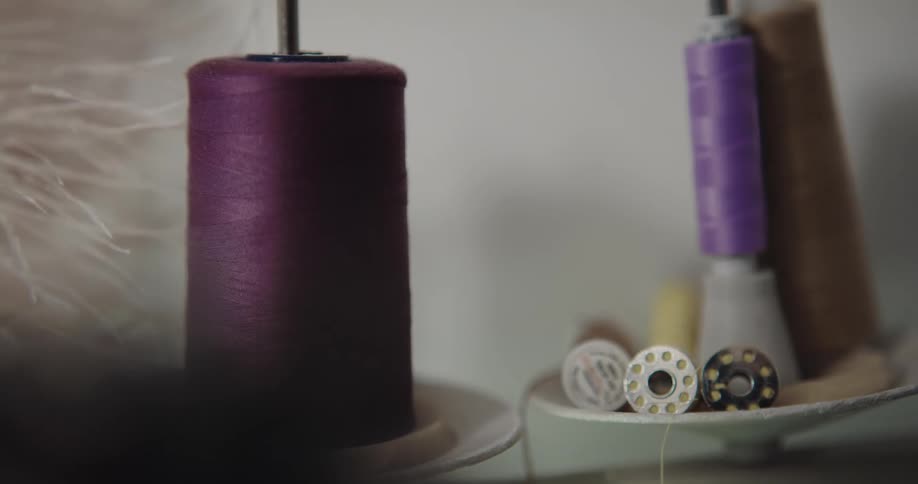 Purple thread on spools and sewing machine bobbins shake and vibrate