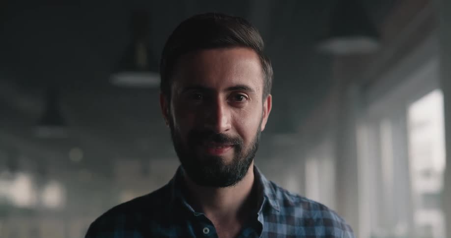 Man standing in structure looks up and smiles