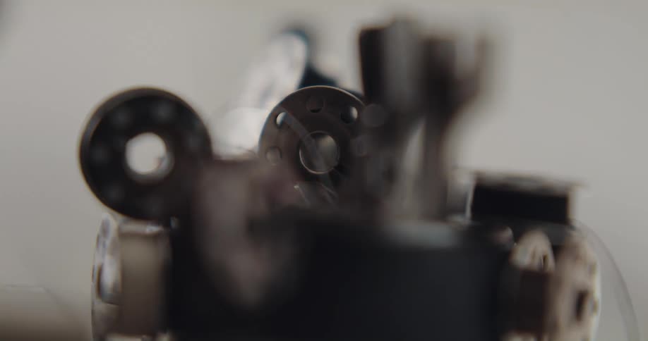 Close up of a person selecting sewing machine presser foots from a small box