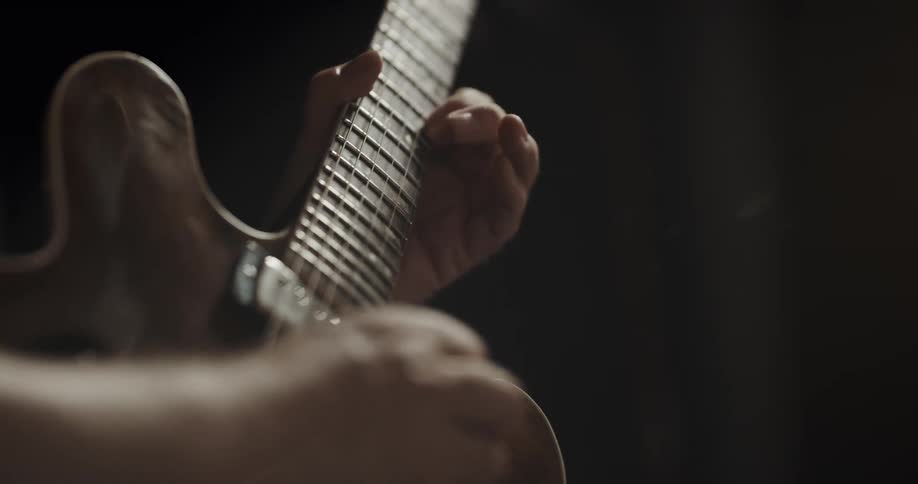 Someone is playing a guitar and strumming the strings