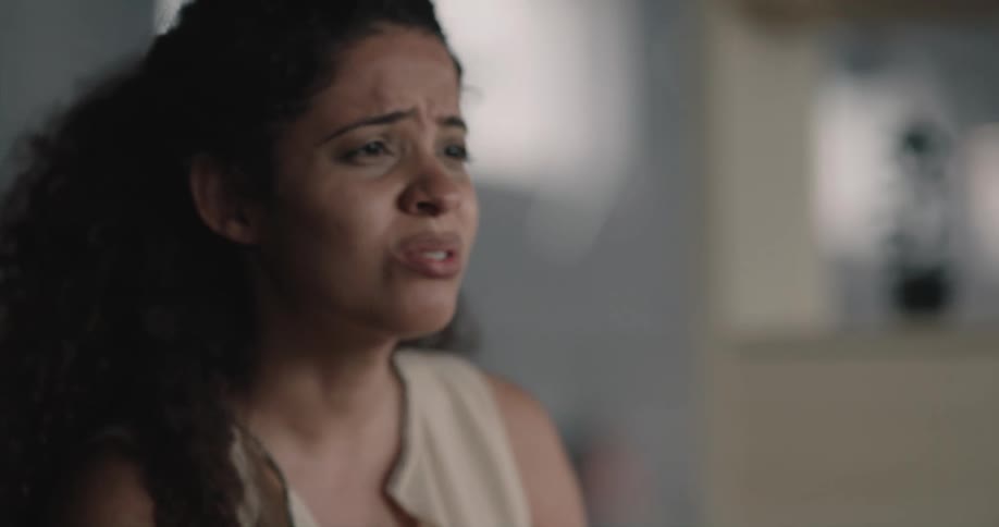 A woman shakes her head while trying to comfort someone