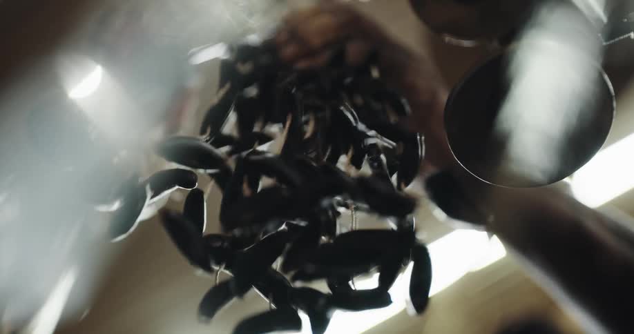 A man shakes objects connected with strings which are hanging from a ceiling