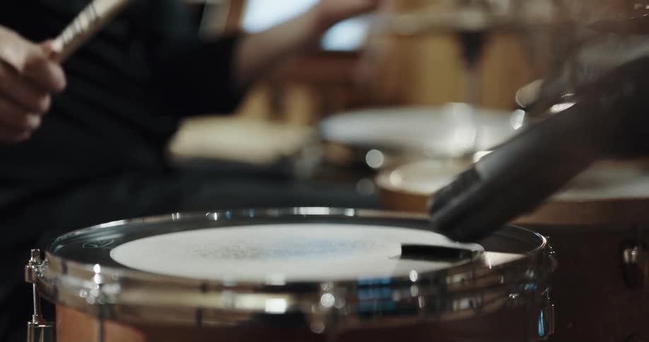 A person is playing the drums indoors