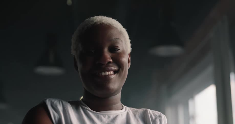 A woman is in a room looking ahead with a big smile on her face