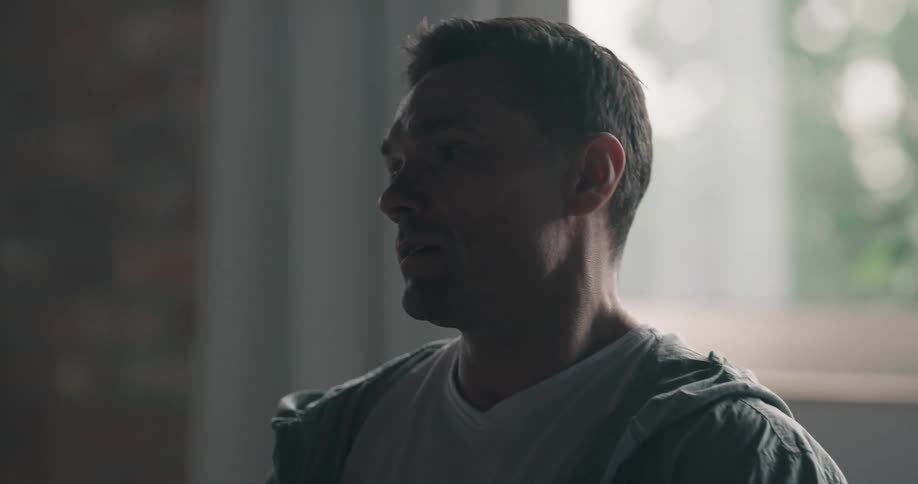 A man is talking near a window in spring