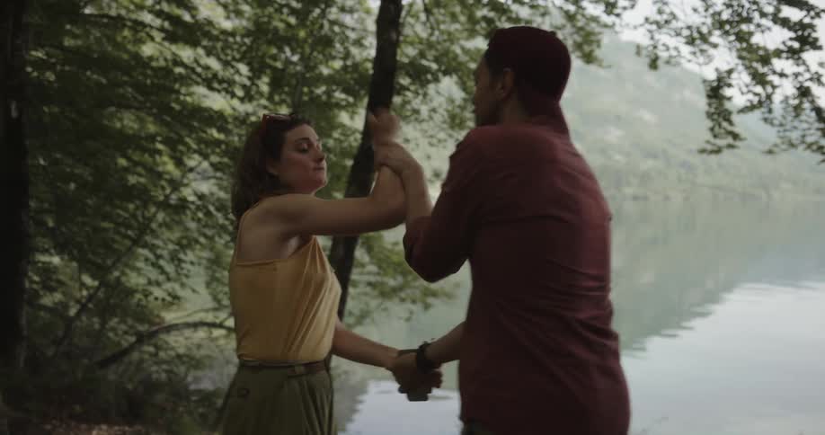 Young couple arguing over a the content of a phone near a lake in the mountains